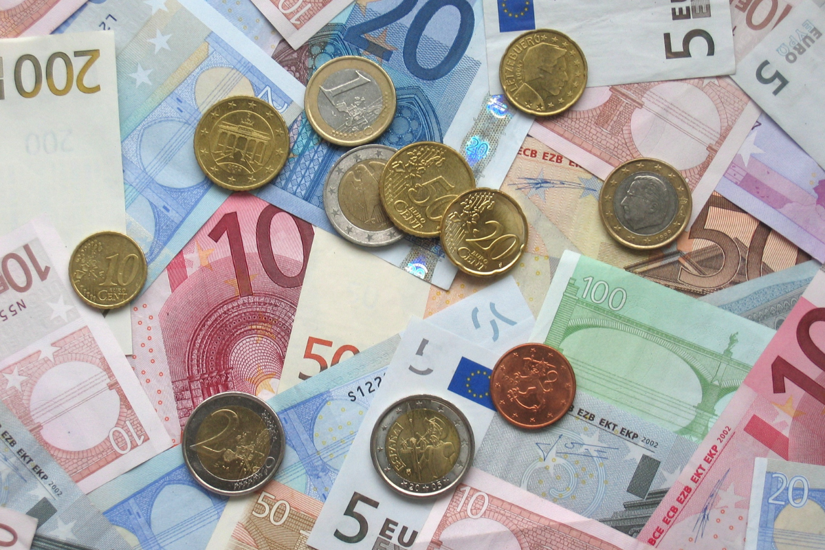 Notas e moedas de Euro amontoadas uma em cima da outra